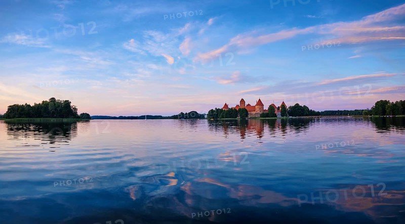 Panorama of Trakai Island Castle in lake Galve, Lithuania on sunset with dramatic sky reflecting in water. Trakai Castle is one of major tourist attractions of Lituania