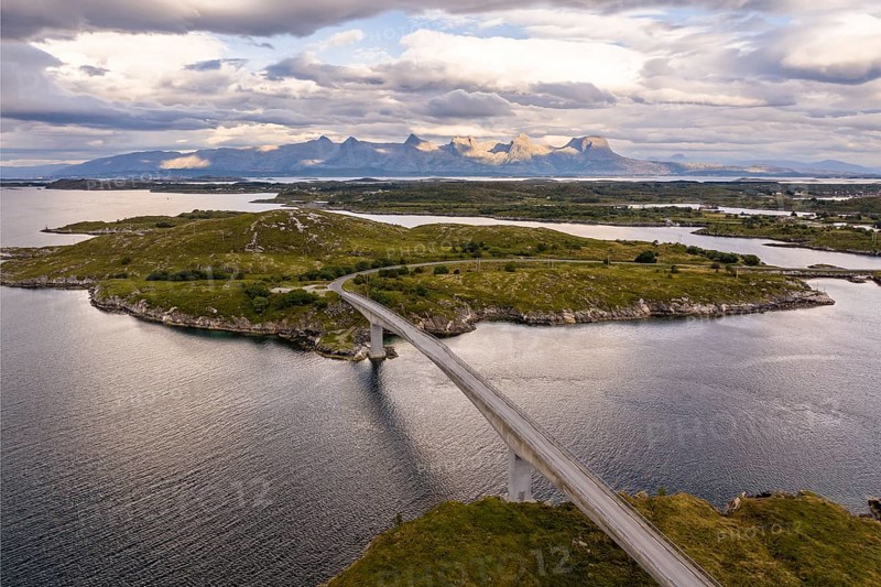 Road with bridge over Inse, behind the mountain range Seven Sisters, Herøy island, Helgeland coast, Nordland, Norway, Europe