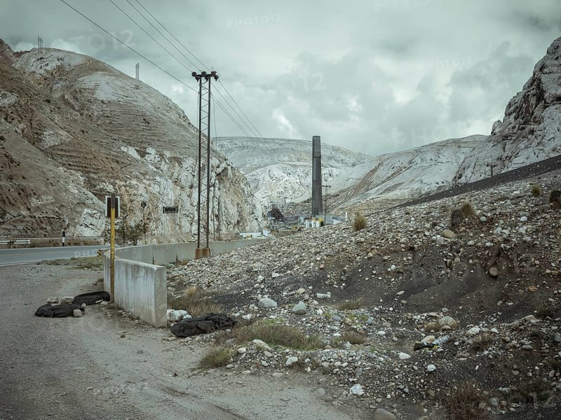 Chimney of the smelter, in the foreground a spoil heap contaminated with heavy metal residues, La Oroya, Peru, South America