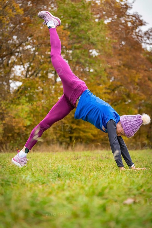 Fitness enthusiast woman practising handstand outside, surrounded by autumn colours, Gechingen, Black Forest, Germany, Europe