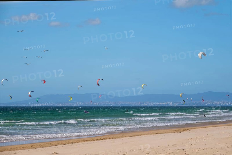 Kiteboarding kitesurfing kiteboarder kitesurfer kites on the Atlantic ocean beach at Fonte da Telha beach, Costa da Caparica, Portugal, Europe