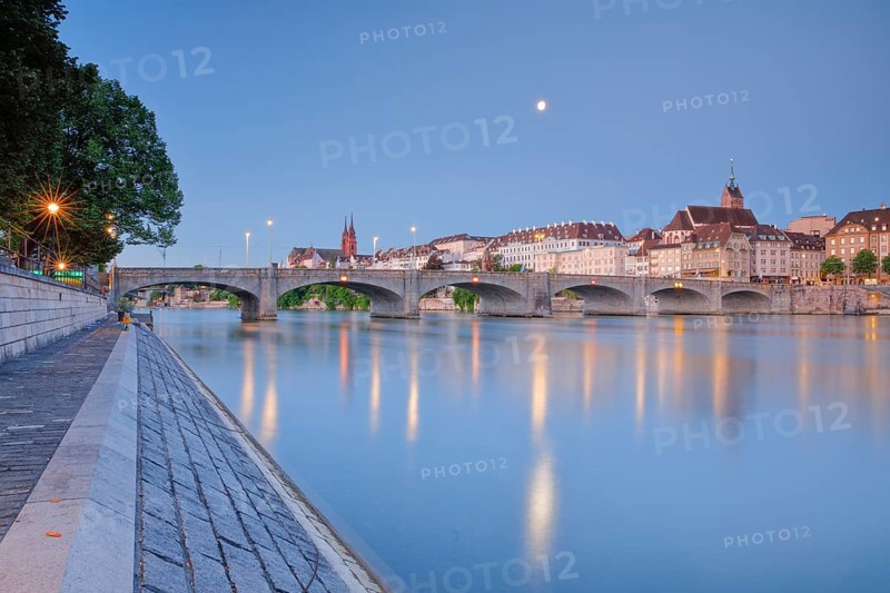 View of the old town of Basel illuminated at night with the Basel Cathedral, St. Martin's Church, the Mittlere Bridge and the Rhine River