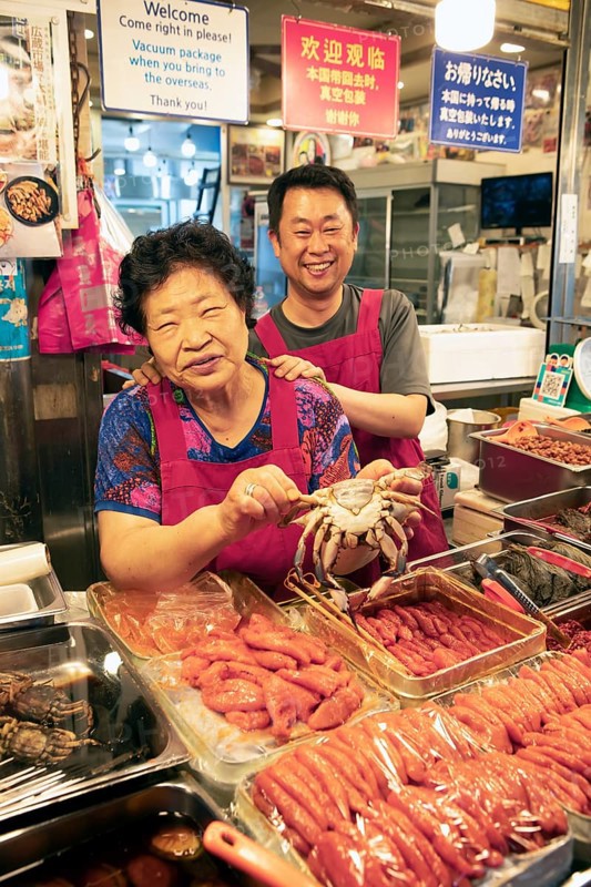 Korean woman and Korean man with a crab, Gwangjang market, traditional street market in Jongno-gu, Seoul, South Korea, Asia