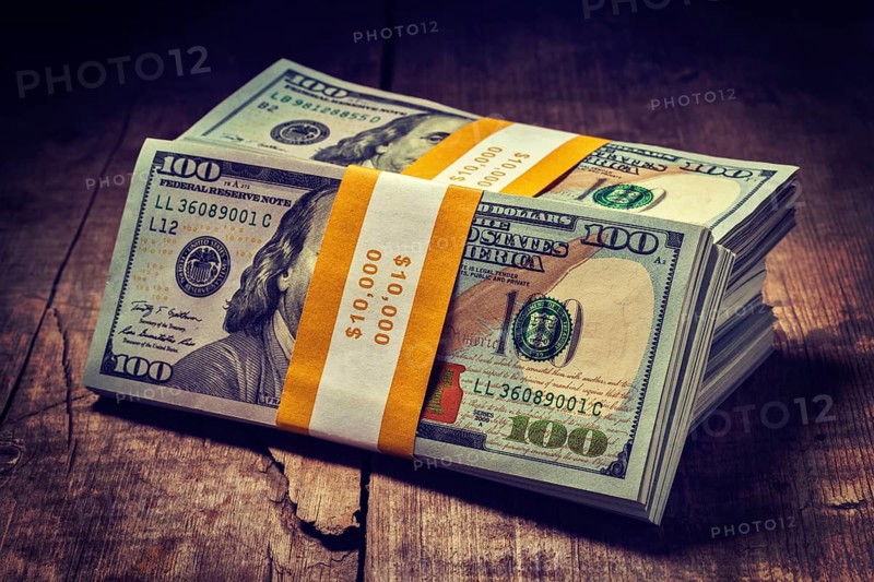 Creative business finance making money concept. Vintage retro effect filtered hipster style image of stacks of new 100 US dollars 2013 edition banknotes bills bundles isolated on wooden background