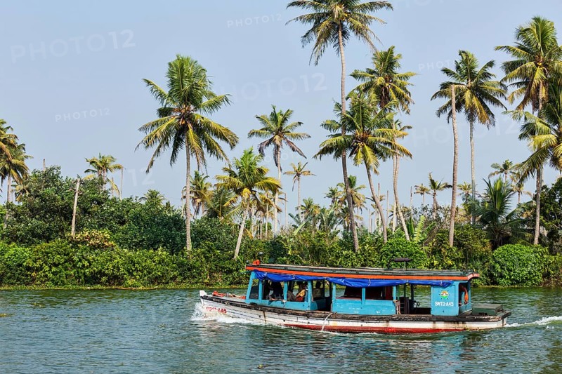 KERALA, INDIA, MAY 5, 2010: Unidentified indian people in small boat in backwaters. Kerala backwaters are both major tourist attraction and integral part of local people life in Kerala
