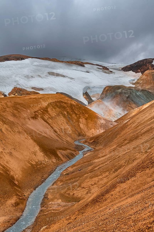 Steaming stream between colourful rhyolite mountains with snowfields, Hveradalir geothermal area, Kerlingarfjöll, Icelandic highlands, Iceland, Europe