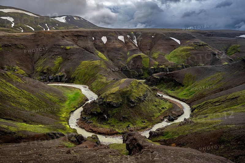 River bend, foot Asgardsa, volcanic landscape with black rocks and green moss, dramatic cloudy sky, Kerlingarfjöll, Icelandic highlands, Iceland, Europe