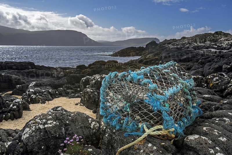 Lobster trap, lobster creel, made of non-degradable plastic and nylon, washed ashore on rocky beach in Scotland, UK