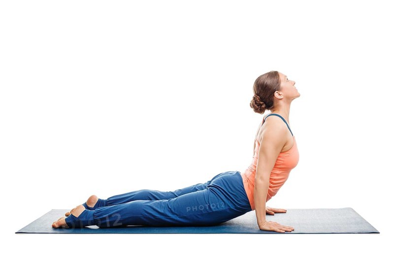 Woman doing Surya Namaskar Sun Salutation Ashtanga Vinyasa Yoga asana Urdhva mukha (Urhdvamukha) svanasana, upward facing dog pose posture isolated on white background