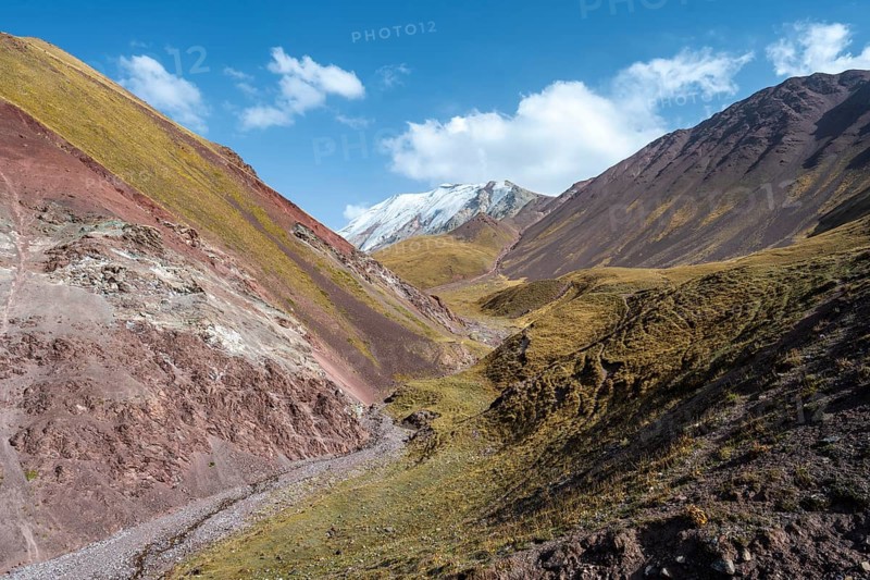 Valley with mountain stream between high mountains in autumn, mountain landscape with glaciated peak Pik ITMO University, Trans Alay Mountains, Pamir Mountains, Osh Province, Kyrgyzstan, Asia