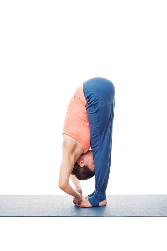 Woman doing Ashtanga Vinyasa Yoga asana Padangushthasana, standing forward bend hand to toe pose posture isolated on white background