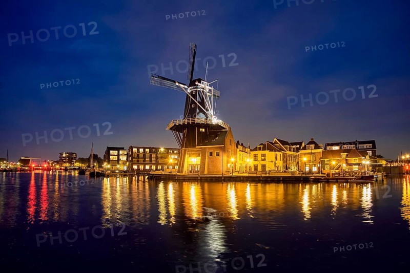 Night view of Harlem landmark windmill De Adriaan on Spaarne river in twilight illuminated. Harlem, Netherlands