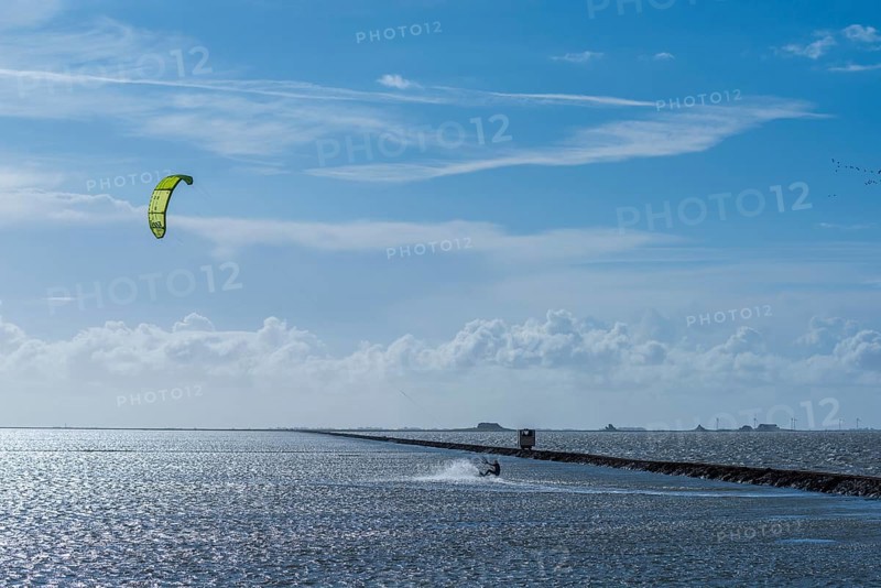 Kitesurfing on the North Sea, Lüttmoorsiel, Reußenköge, on the horizon Hallig Nordstrandischmoor, Lorendamm, wind power, wind force 6, blue sky, North Frisia, Schleswig-Holstein, Germany, Europe