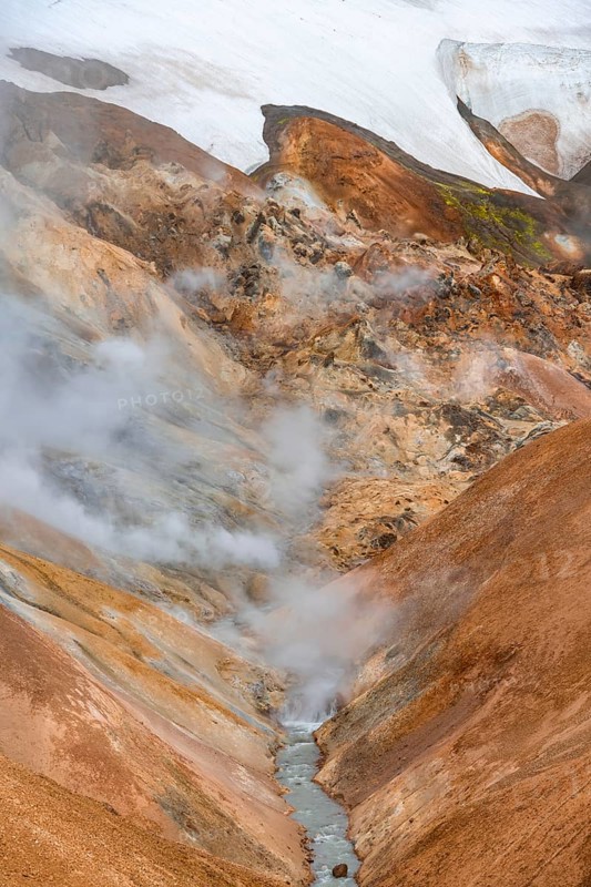 Steaming stream between colourful rhyolite mountains and snowfields, Hveradalir geothermal area, Kerlingarfjöll, Icelandic Highlands, Iceland, Europe