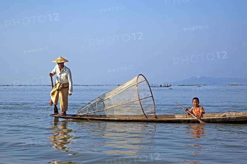 Intha fisherman steering traditional fishing boat by wrapping his leg around the oar, Inle Lake, Nyaungshwe, Shan State, Myanmar, Burma, Asia