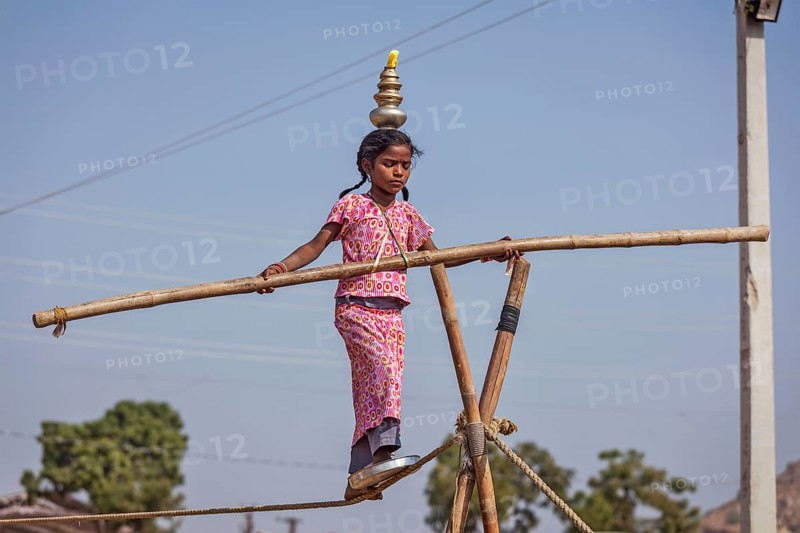 PUSHKAR, INDIA, NOVEMBER 21, 2012: Unidentified indian girl street acrobat walks the tightrope at annual camel fair Pushkar Mela in Pushkar, Rajasthan, India, Asia