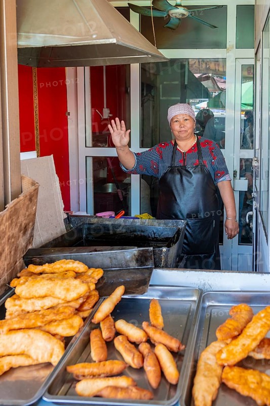 Vendor at the market stall selling pastries, Uzgen Bazaar, Ösgön, Osh region, Kyrgyzstan, Asia