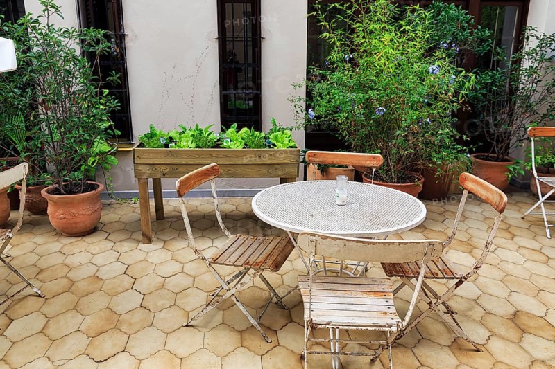 Roof terrace in a hostel, hotel, simple round table, folding chairs, raised flower bed, flower pots, Gracia district, Barcelona, Spain, Europe