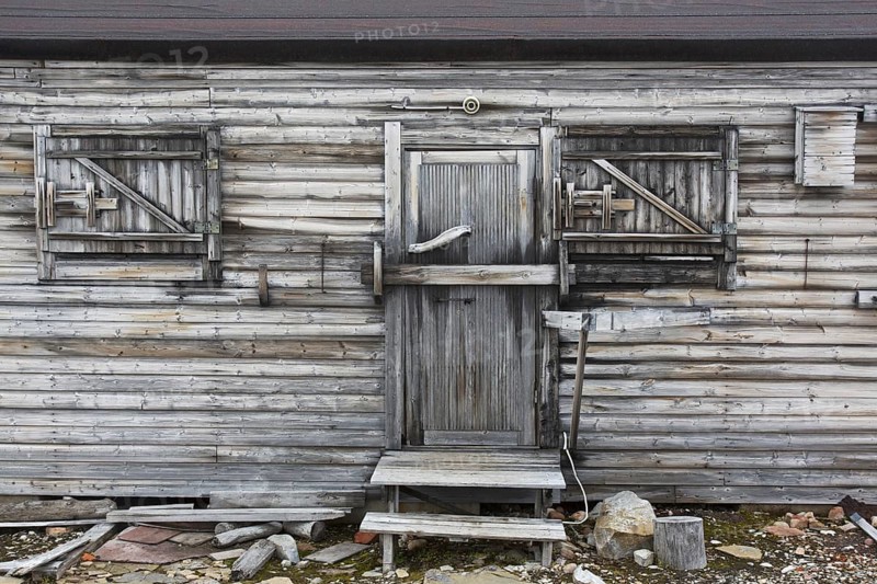Closed door and windows of wooden cabin at deserted Kinnvika Arctic research station, Murchisonfjord, Nordaustlandet, Svalbard, Spitsbergen, Norway, Europe