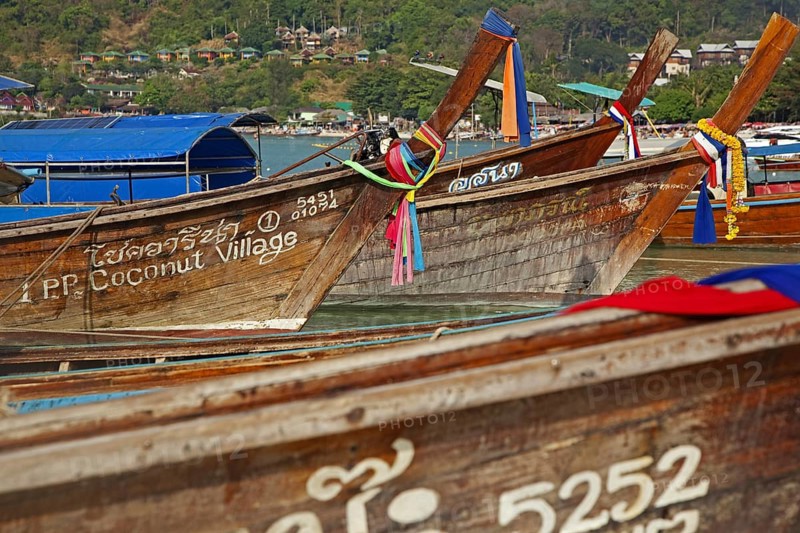 Prows of traditional wooden fishing boats on beach of one of the Ko Phi Phi islands, Southern Thailand