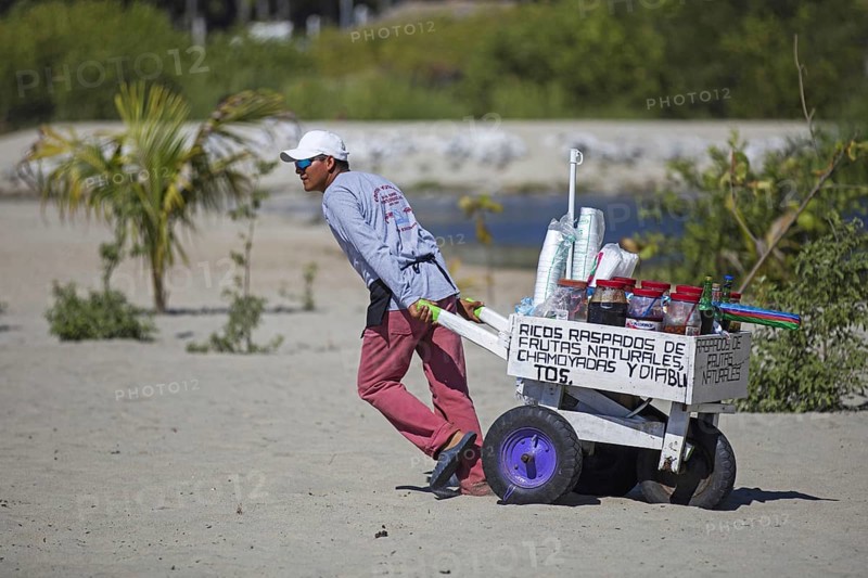 Beach vendor pulling cart with drinks at Playa Principal near Puerto Escondido, San Pedro Mixtepec, Oaxaca, Mexico, Central America