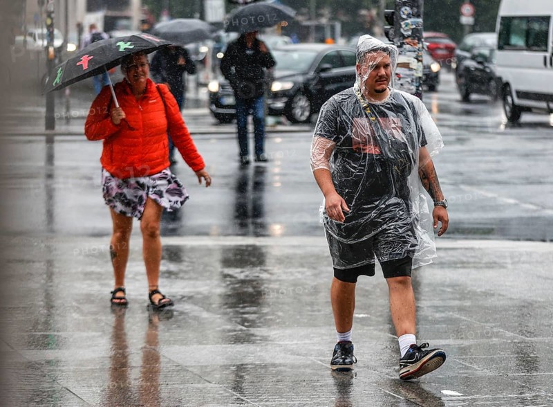 Tourists with rain capes and umbrellas during heavy rainfall, Berlin, 23 06 2023