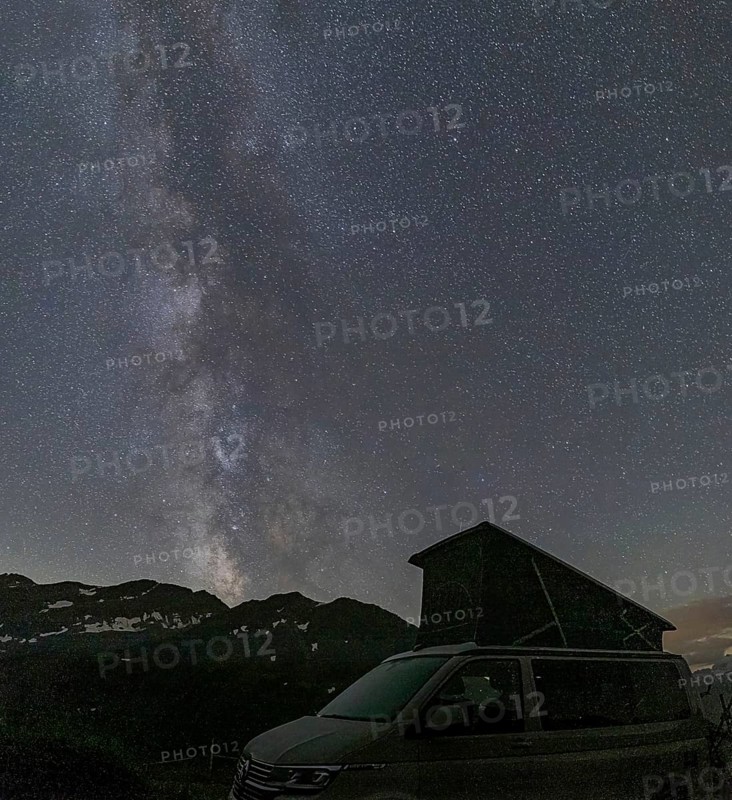 Nocturnal starry sky over the Furka Pass in the Swiss Alps. The night photograph shows the stars of the Milky Way and shooting stars. Obergoms, Valais, Switzerland, Europe