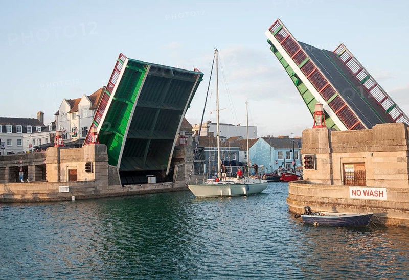 Town bridge raised to allow a yacht to pass into the marina in Weymouth harbour, Dorset, England, UK