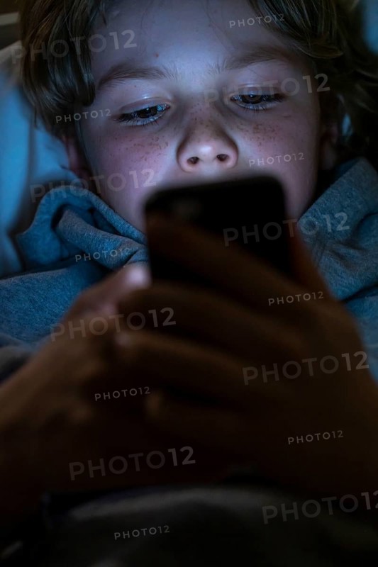 A boy plays computer games on a mobile phone, smartphone