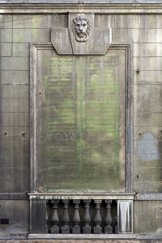 Lion's head above an emission-soiled window of an abandoned palazzo, historic centre, Genoa, Italy, Europe