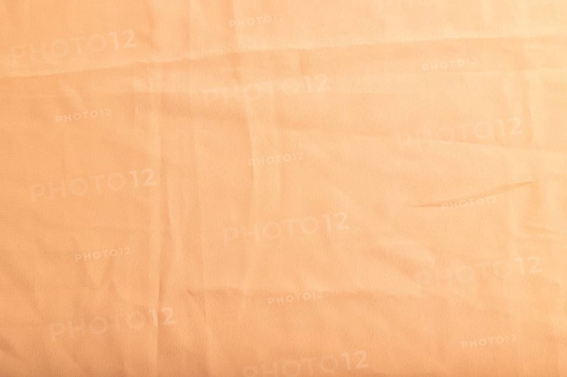 Fragment of smooth orange linen tissue. Top view, flat lay, natural textile background and texture