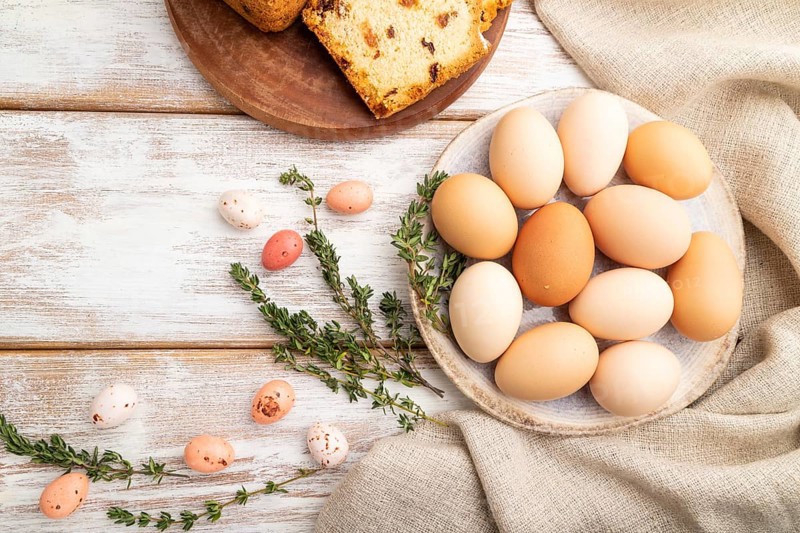 Homemade easter pie with raisins and eggs on plate on a white wooden background and linen textile. top view, flat lay, close up