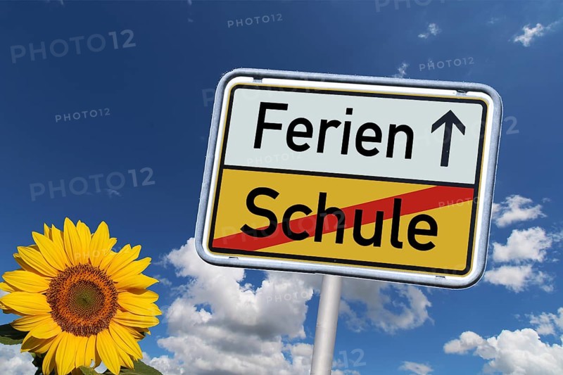 Symbolic image: German town exit sign with the words Schule/Ferien against a blue sky