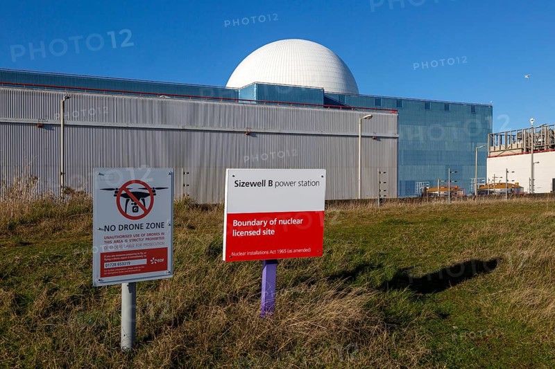 Signs boundary and no drone zone with white dome of Sizewell B power station, Suffolk, England, UK