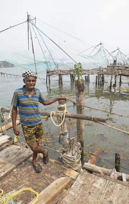 Indian fisherman standing at Chinese fishing nets, behind the Arabian Sea, Kochi, Kerala, India, Asia