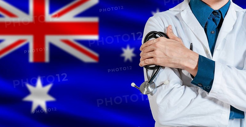 Doctor with stethoscope on Australia flag. Male Doctor holding stethoscope on Australian flag