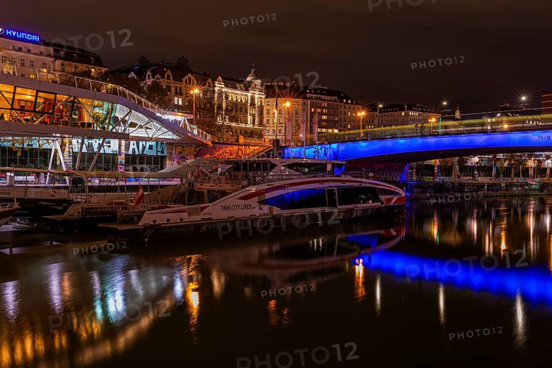 Ferry anchored in the Danube Canal, behind the illuminated Franz-Josefs Quay and St Mary's Bridge, night shot, Vienna, Austria, Europe