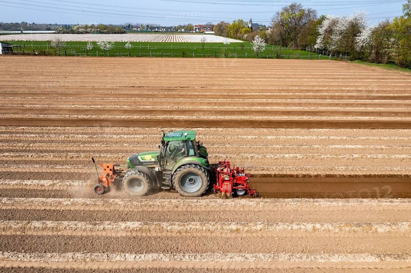 A farmer builds asparagus ridges on a field with the help of an asparagus tiller, in which the asparagus then grows, Dormagen, North Rhine-Westphalia, Germany, Europe