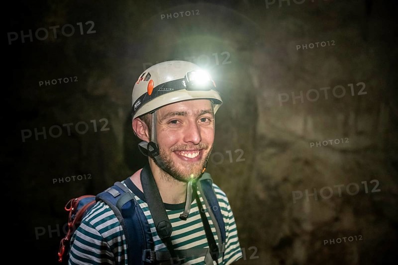 Young man with helmet and headlamp in a stalactite cave, Terciopelo Cave, Barra Honda National Park, Costa Rica, Central America