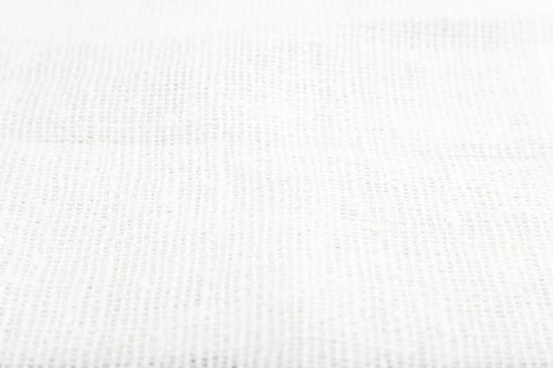 Fragment of smooth white linen tissue. Side view, natural textile background and texture