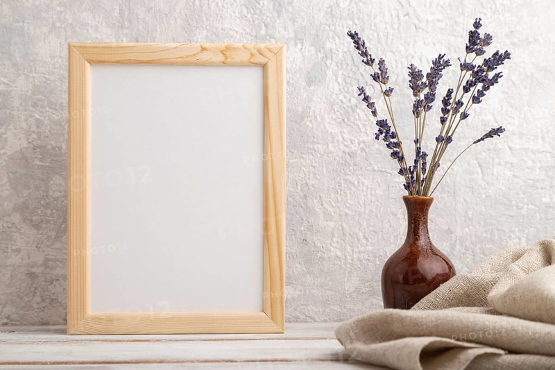 White wooden frame mockup with lavender in ceramic vase and linen textile on gray concrete background. Blank, vertical orientation, still life