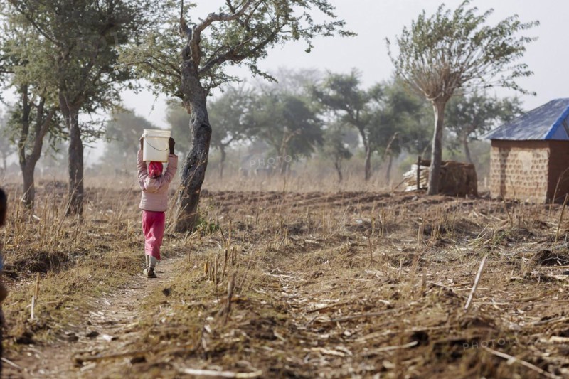 Girl carrying a heavy bucket of water on her head, Maraban Dare, 07/02/2024