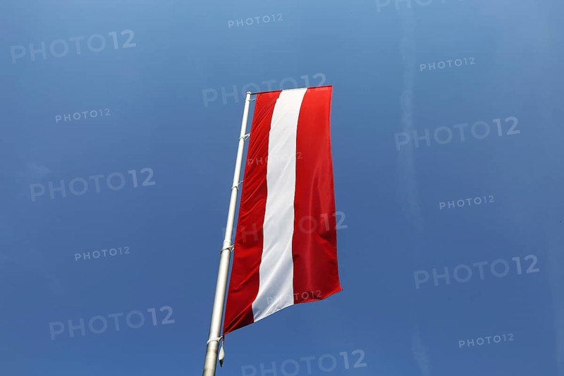 Österreichische Flagge vor blauem Himmel (Austrian flag in front of a blue sky)