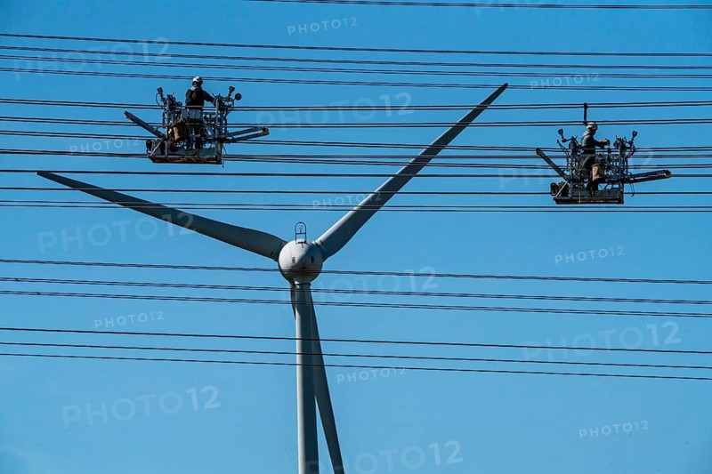Construction of a new line route, 380 KV extra-high voltage line between Osterath and Gohr, near Neuss, fitters in cable trolleys, on the conductor cables, installing field spacers at great heights, wind power station, North Rhine-Westphalia, Germany, Europe