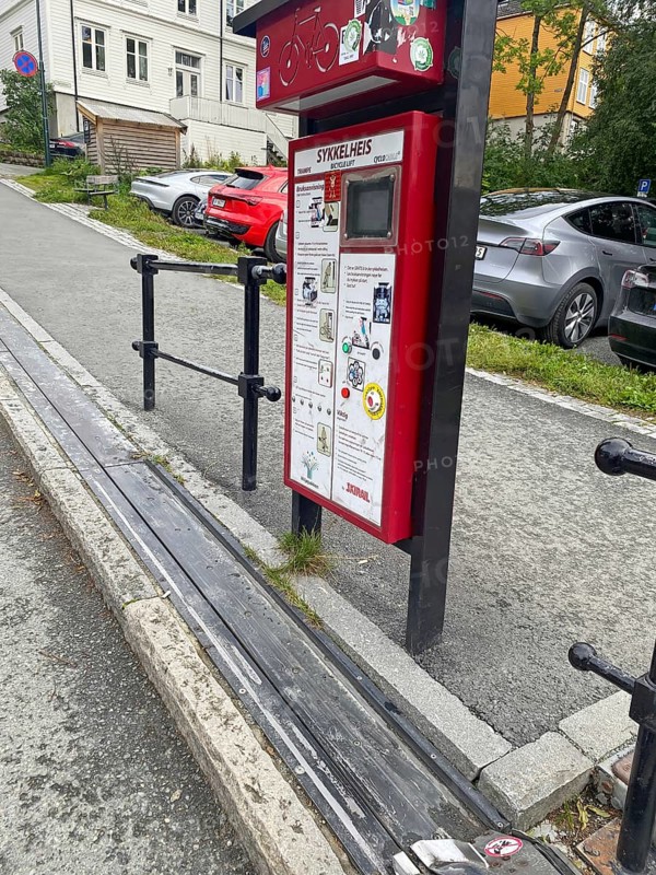 The world's only bicycle lift on a steep street with parked cars and pavement, Nidarelva, Trondheim, Tröndelag, Norway, Europe