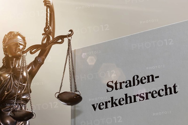 Symbolic image: Textbook on traffic law and a Justitia