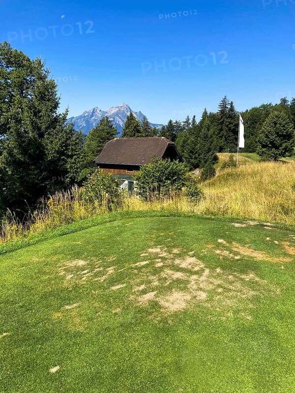 Golf Course with Mountain View and Peak Pilatus and the Moon in a Sunny Summer Day in Burgenstock, Nidwalden, Switzerland, Europe