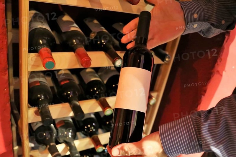 Symbolic image: Sommelier presents a bottle of red wine