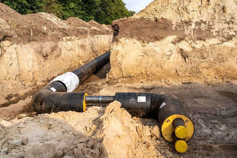 Laying of district heating pipes, next to a field, with maize, the district heating comes from a biogas plant and is fed directly into households in the neighbourhood, private provider, near Delbrück, North Rhine-Westphalia, Germany, Europe