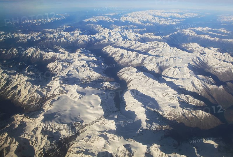 View from plane of snow covered mountain peaks in the Alps between France and Italy